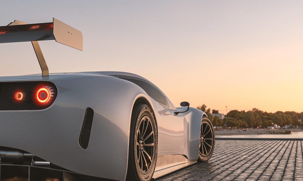 high-performance supercar parked on a waterfront plaza at sunset.