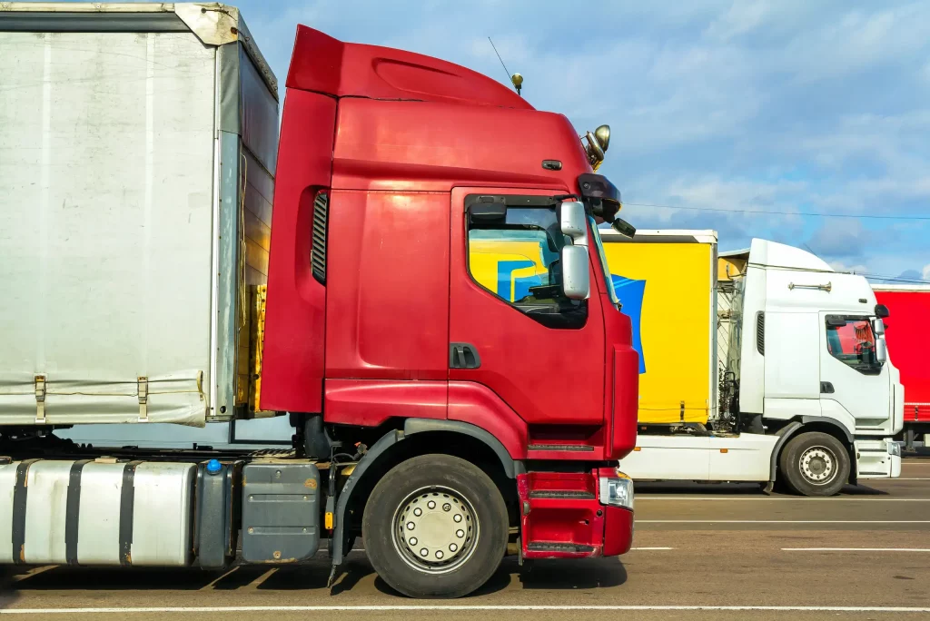 Commercial semi-trucks parked in a transport lot, representing how fleet vehicle registration works across multiple states.
