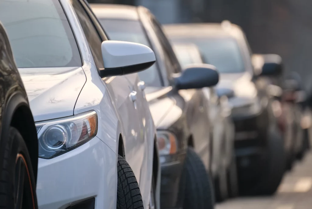 A line of cars parked on a city street, illustrating the need for efficient Billings Montana vehicle registration for businesses and fleets.